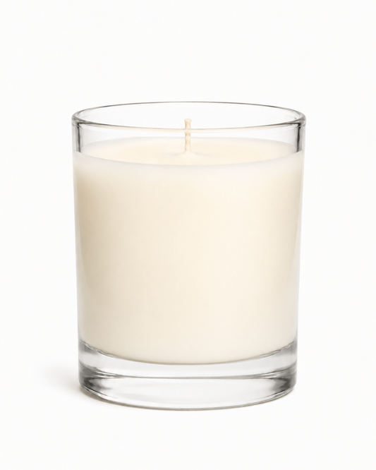 Clear glass candle with white wax inside on a white background